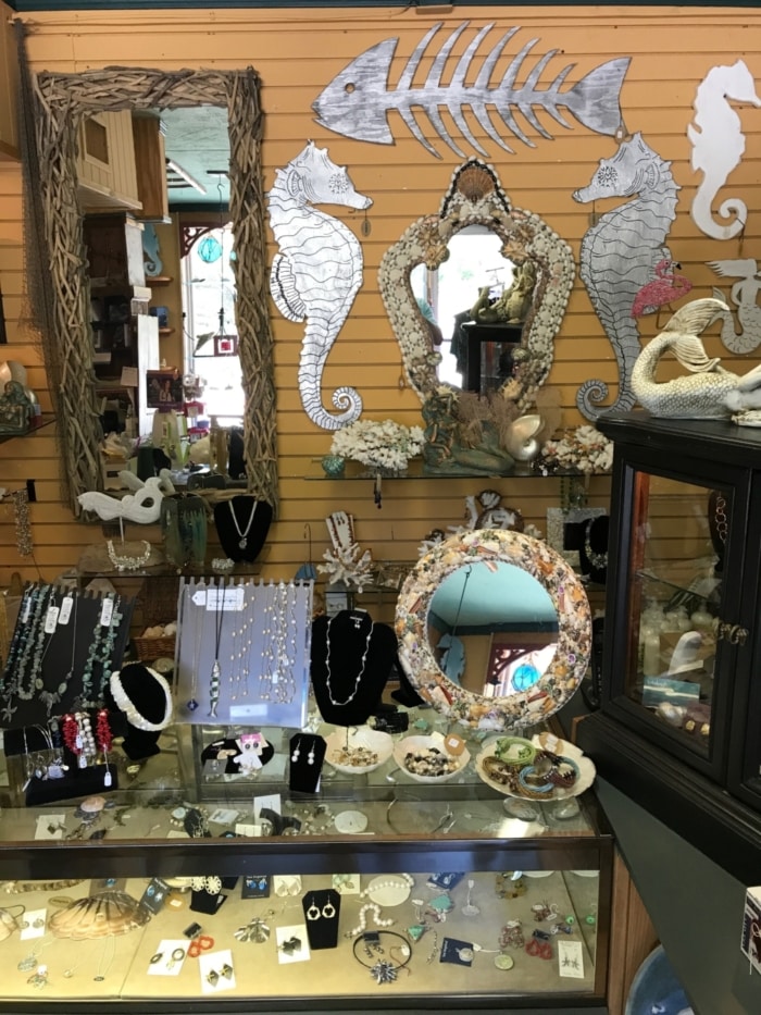 Earrings and necklaces being shown in glass jewelry display case